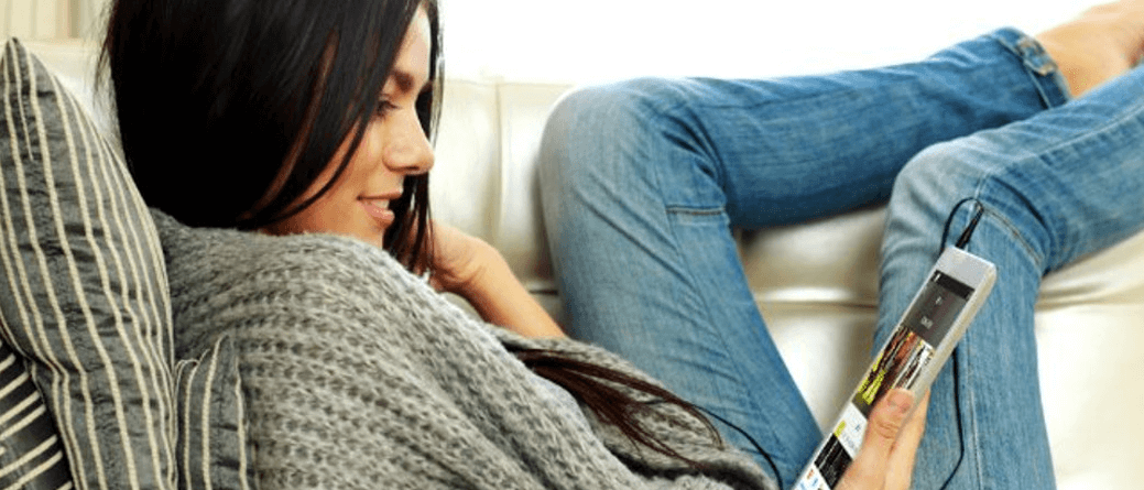 Woman using tablet as a second screen in multiscreen TV service